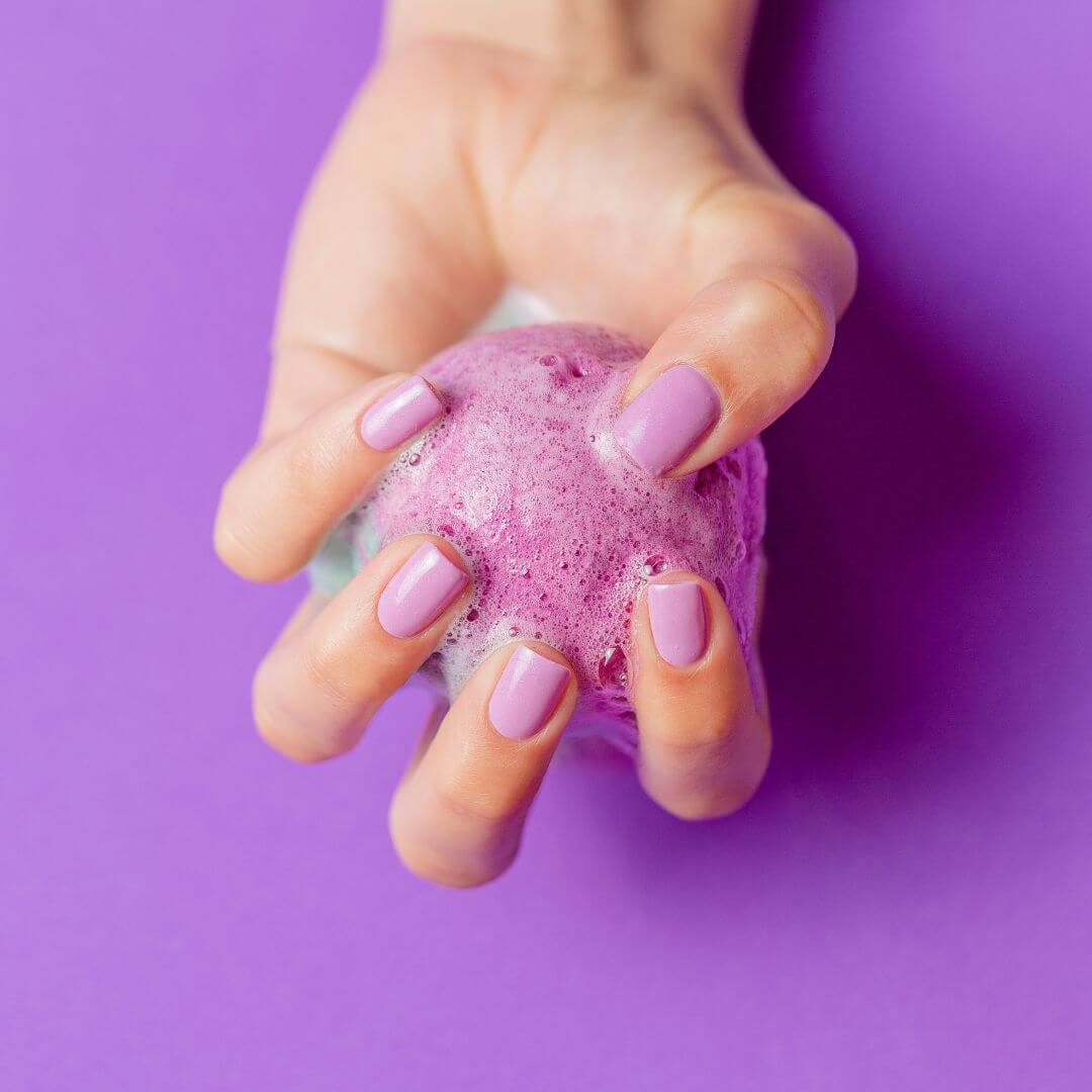 Lavender bath bomb fizzing in hand