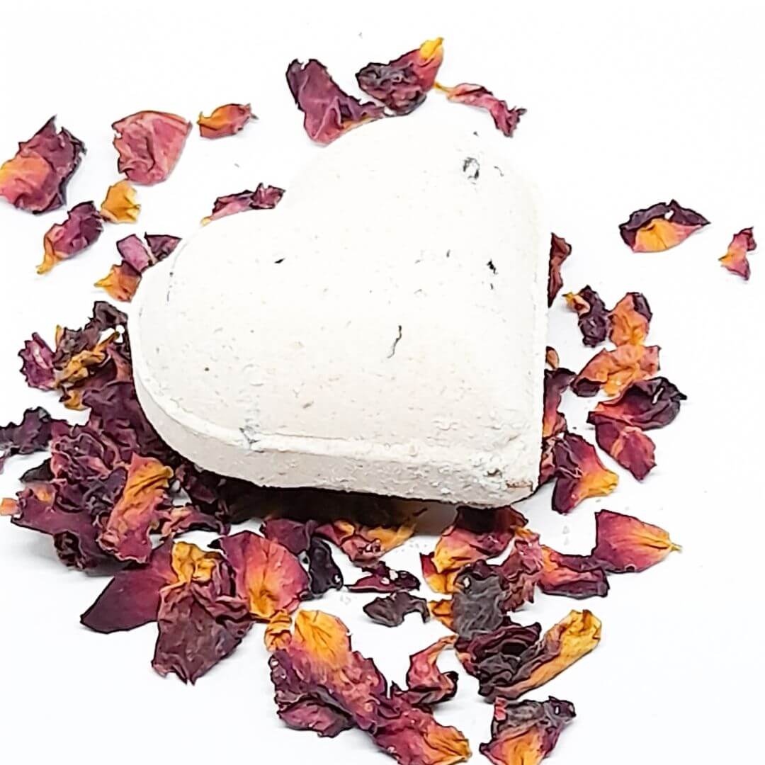 heart shaped geranium bath bomb lying on rose petals