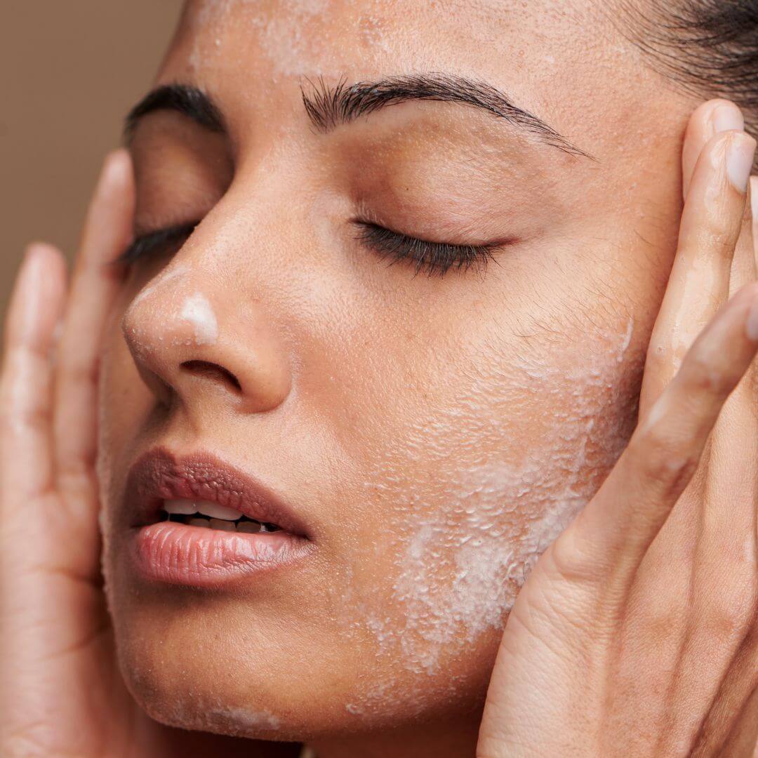 woman washing cleansing balm off her face